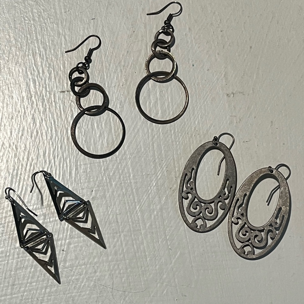 Three pairs of dangling silver metal earrings